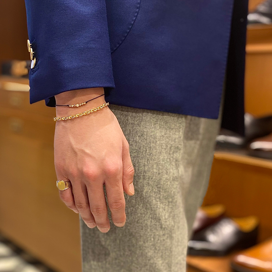 左手の小指にシグネットリングを着用した男性の手元